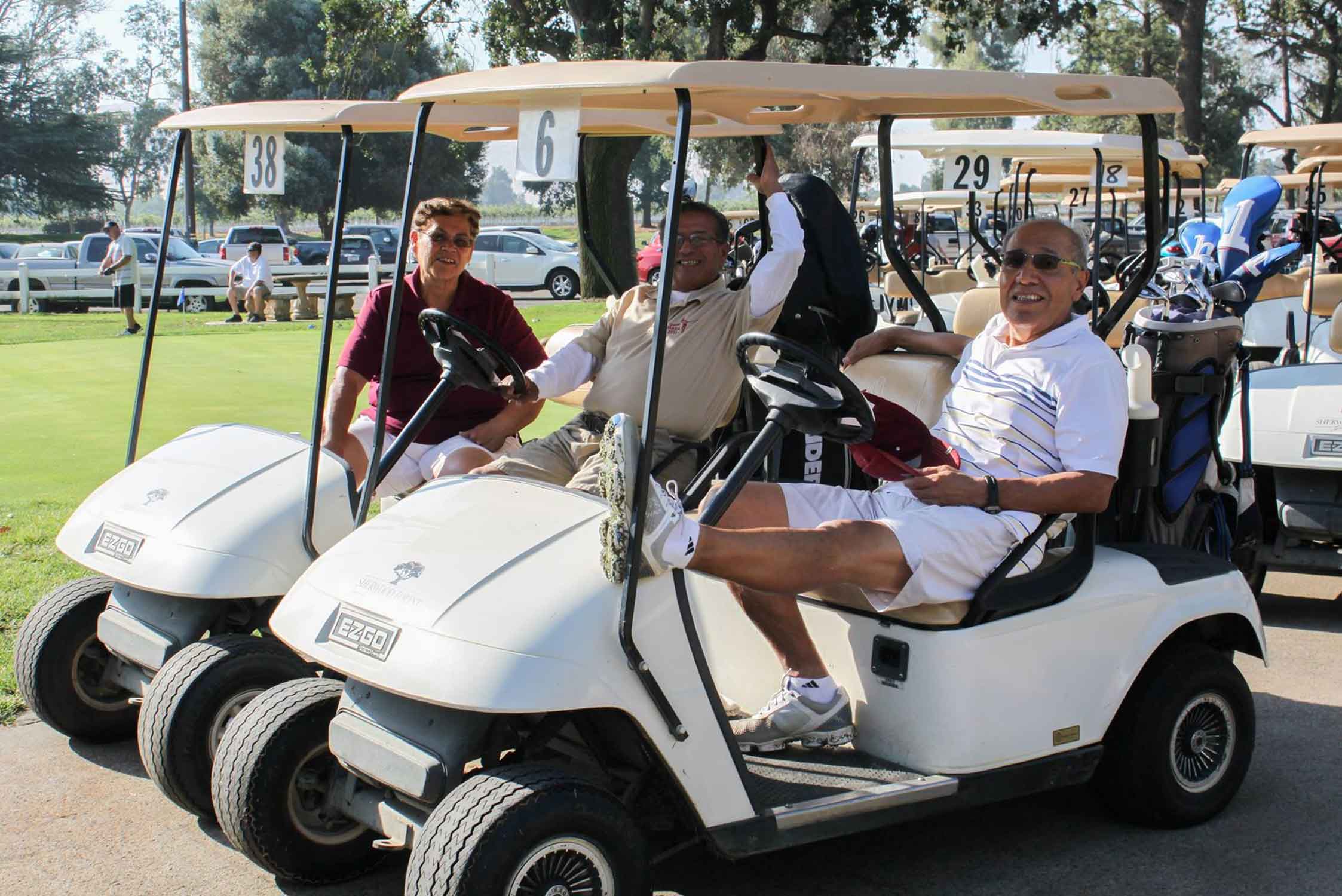Men sitting in golf carts and smiling.
